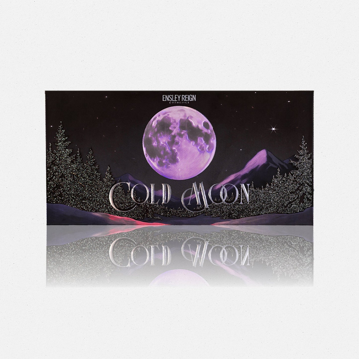 Cold Moon by Ensley Reign Cosmetics - closed packaging with purple full moon over a snowy mountain and pine tree landscape, reflected on grey surface