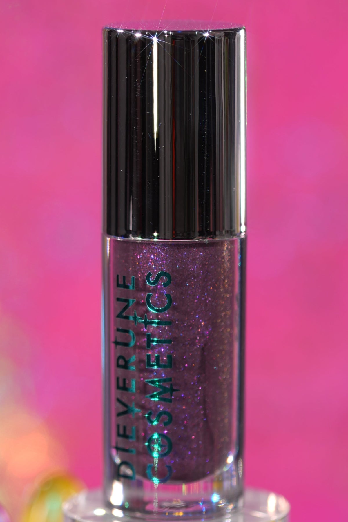 Purple Potion tube standing upright on a pink backdrop, logo side facing out