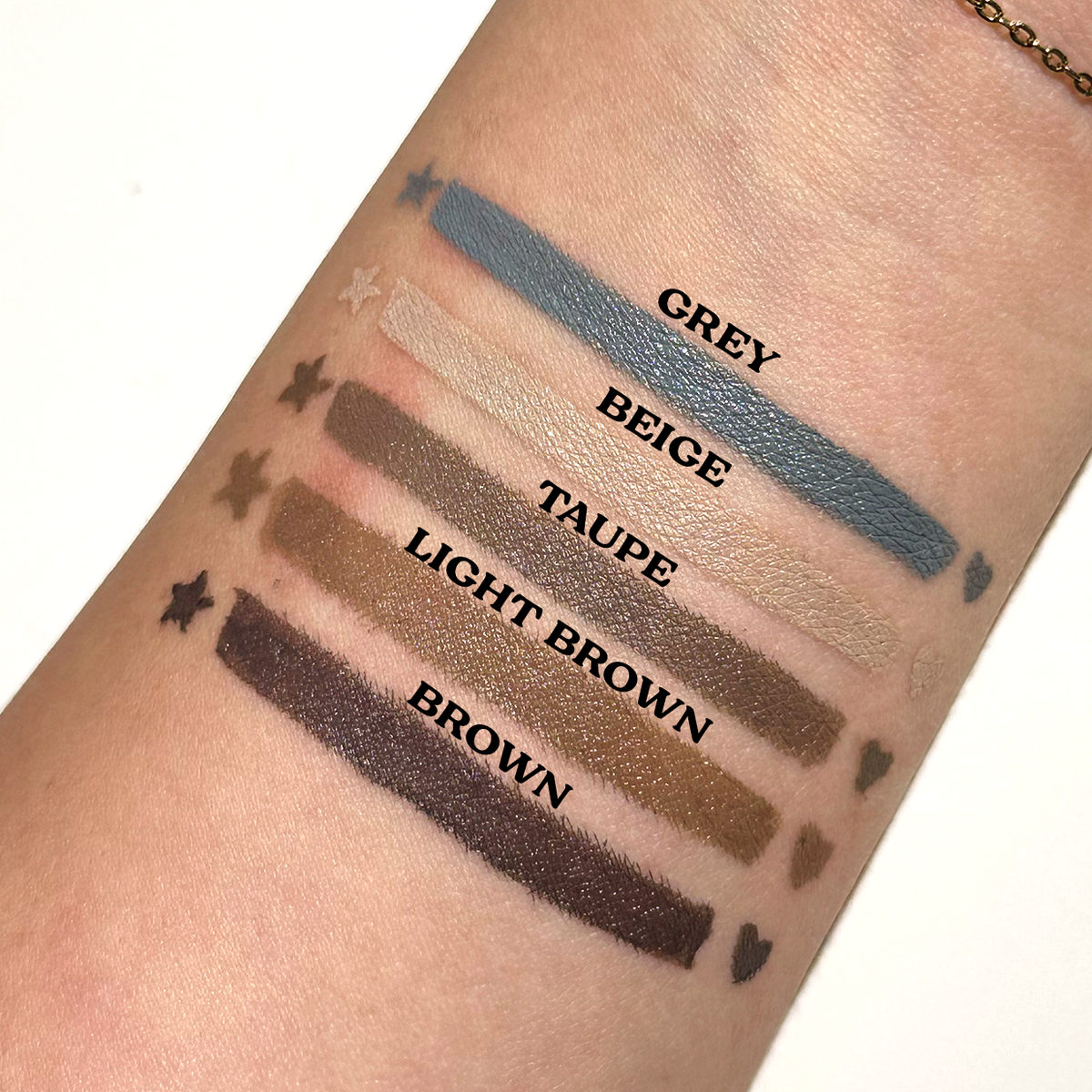 Arm swatches of the five neutral Spectra Pens with star and heart stamps: grey, beige, taupe, light brown and brown