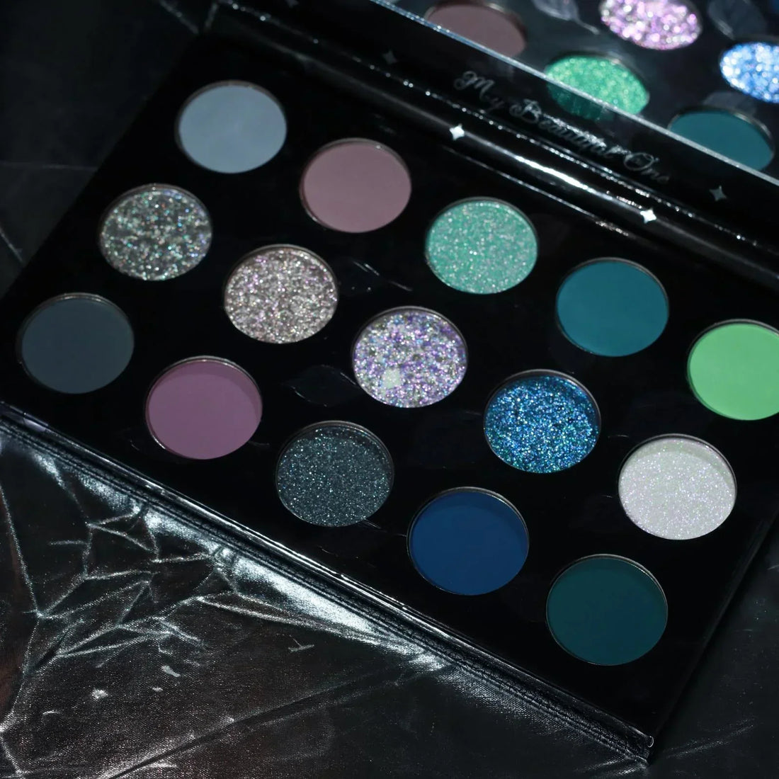 Dieverune Silver and Cold eyeshadow palette, fifteen pans in icy blues, teals, and greys with shifty shimmers and deep mattes