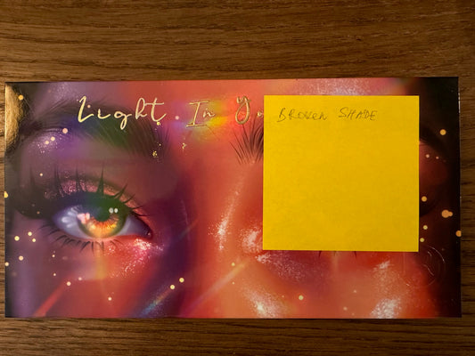 LOT #010 - Light in Your Eyes eyeshadow palette (Ensley Reign). Damaged sleeve and cover. One broken shade.