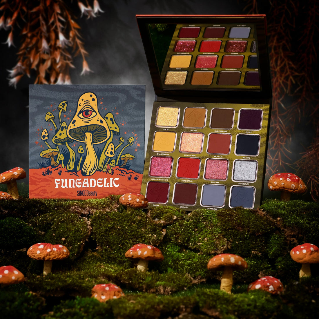 Fungadelic box and open palette with its mirror on moss among toy red toadstools, against a dark misty backdrop