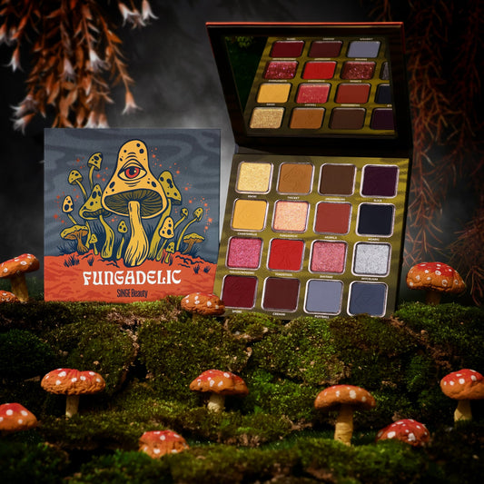 Fungadelic box and open palette with its mirror on moss among toy red toadstools, against a dark misty backdrop