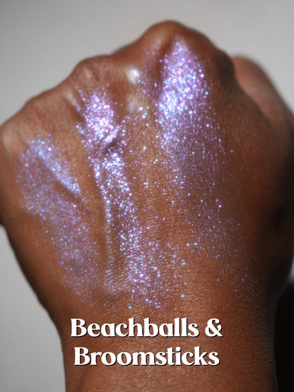 Beachballs and Broomsticks blended across the back of a hand on deep skin, lilac with blue sparkle.