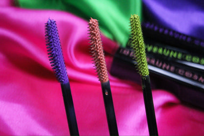 Three loaded wands standing upright against pink and green satin, orchid, coral and chartreuse.