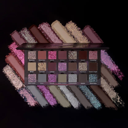 Ensley Reign Cold Moon eyeshadow palette open, 21 shades across three rows: pinks, mauves, and neutrals with sparkle accents, fan-swatched on black