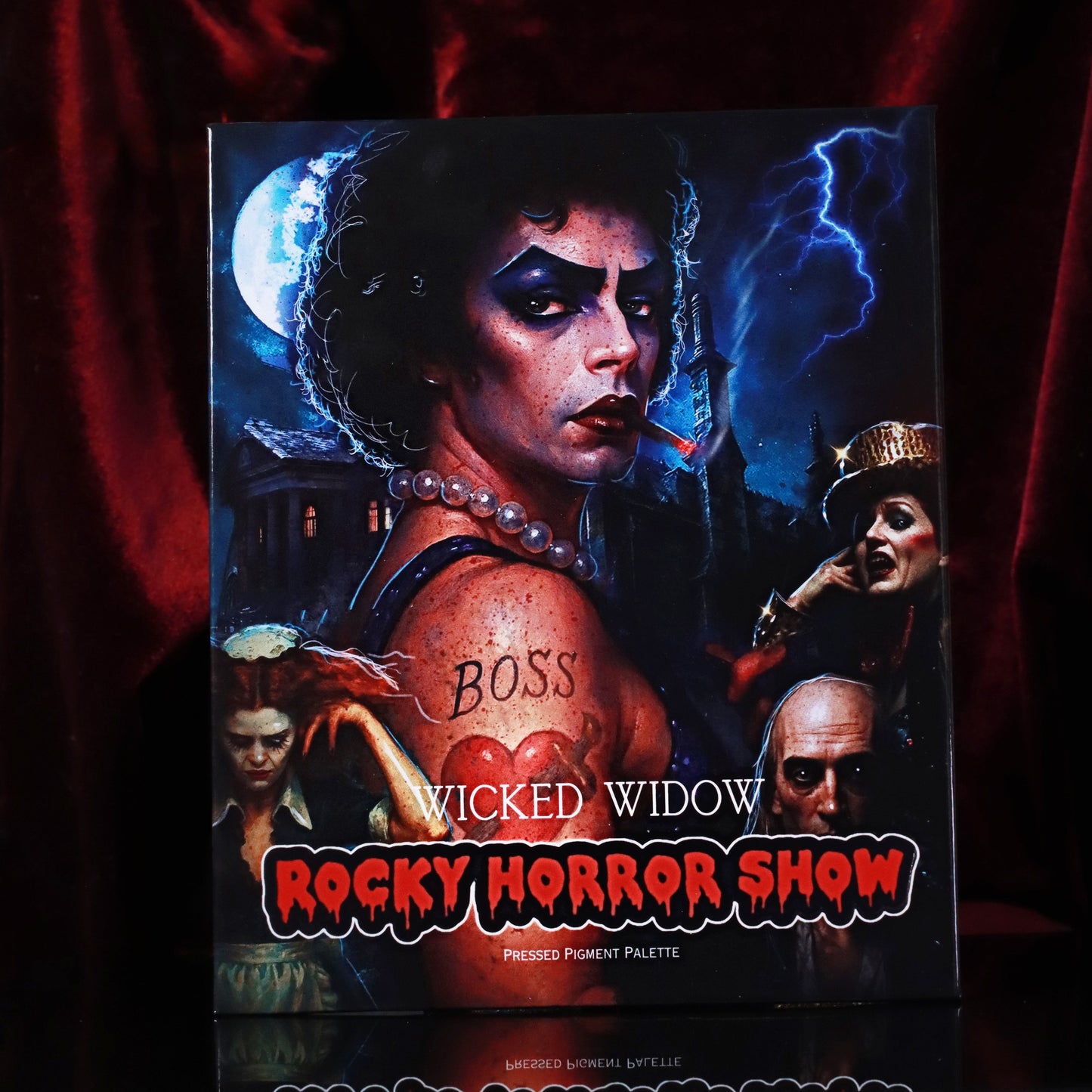 Wicked Widow Beauty Rocky Horror Show pressed pigment palette box front featuring Frank-N-Furter artwork against red velvet