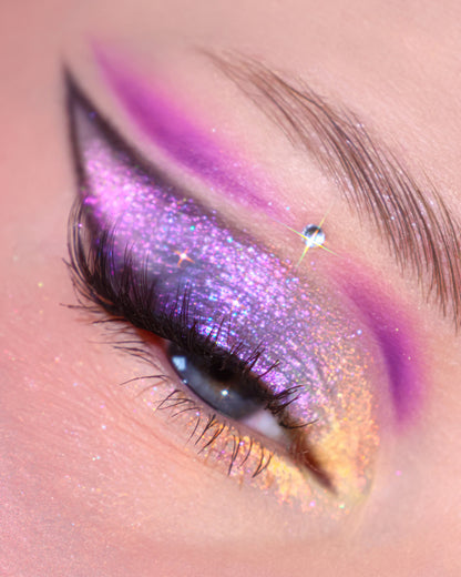 Close-up eye look using Change the Channel, a pink and violet sparkling lid with a bright orchid cut crease and golden lower lash line
