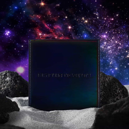 Kryptein Supernova palette closed, iridescent black cover with subtle colour shift, staged on lunar rock against a nebula backdrop