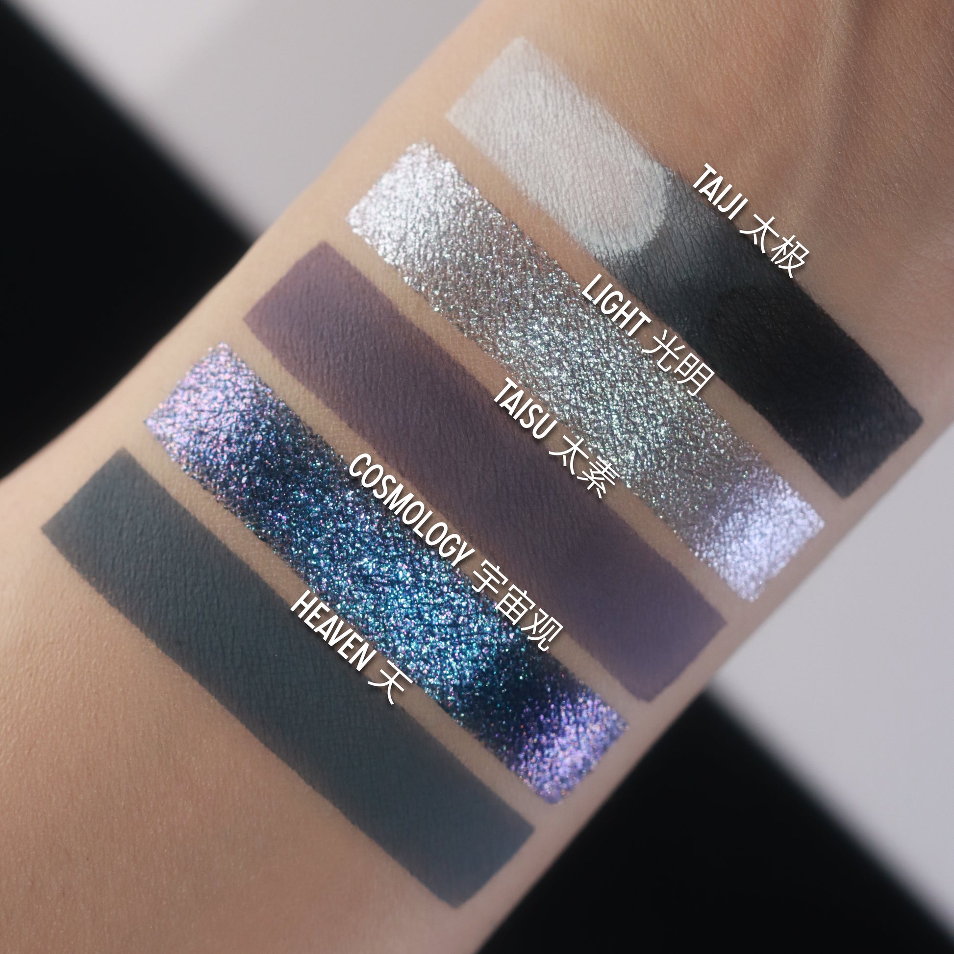 BellaBeauteBar Yin & Yang palette shade swatches — Taiji, Light, Taisu, Cosmology, and Heaven — silver glitter, matte black, lilac shimmer, and deep teal-blue multichrome