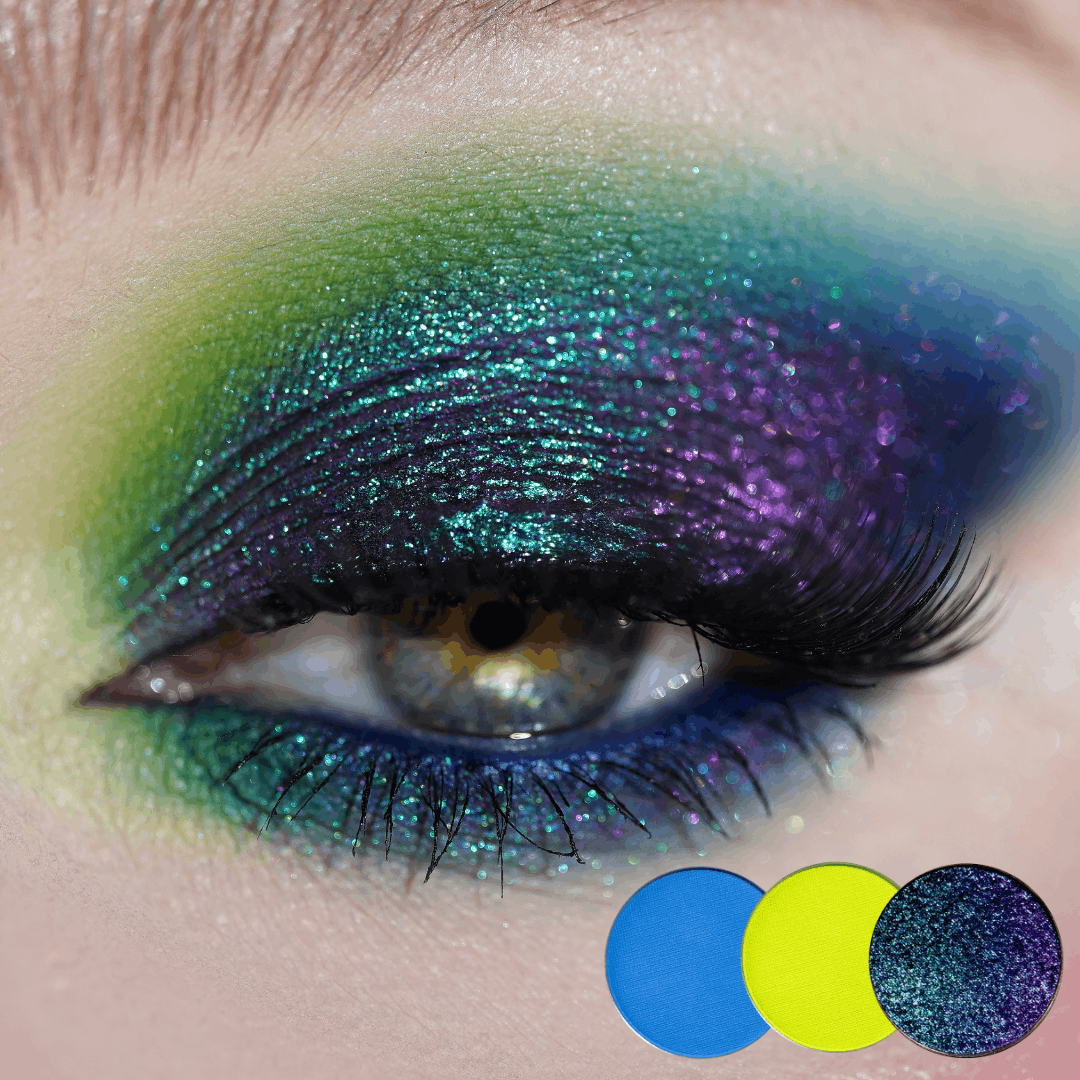 Close-up of a hazel eye with green, teal and purple multichrome shadow blended across the lid and lower lash line, three round shade dots below.