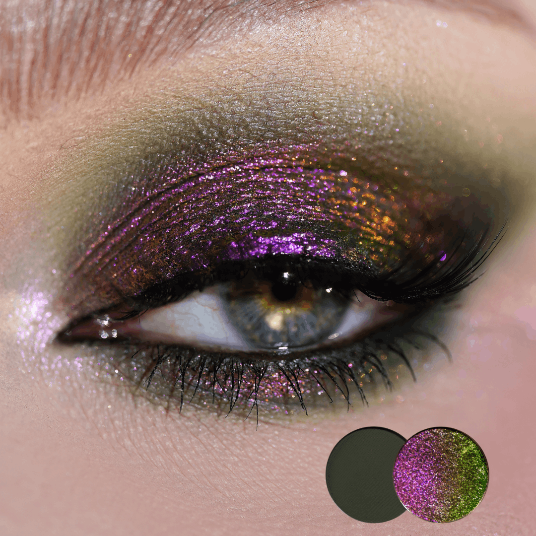 Close-up of a blue eye with magenta pink and copper green multichrome shadow across the lid, two round shade dots in the corner.