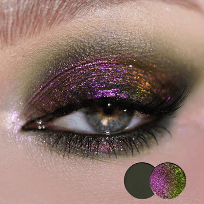 Close-up of a blue eye with magenta pink and copper green multichrome shadow across the lid, two round shade dots in the corner.