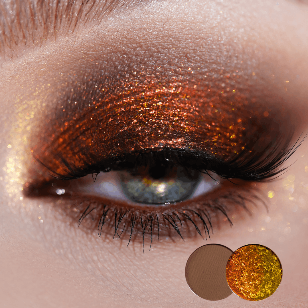 Close-up of a green eye with copper orange shimmer and brown matte crease, two round shade dots in the corner showing the pair used.