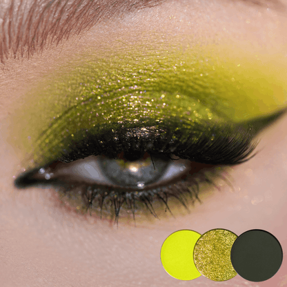Close-up of a green eye with bright chartreuse yellow shimmer on the lid and deep olive in the crease, three round shade dots below.