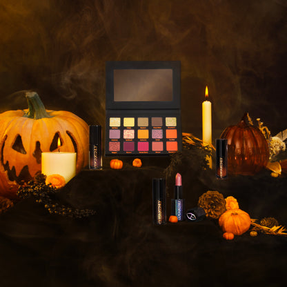 The open palette staged with the collection lipstick and glosses among carved pumpkins, candles and smoke