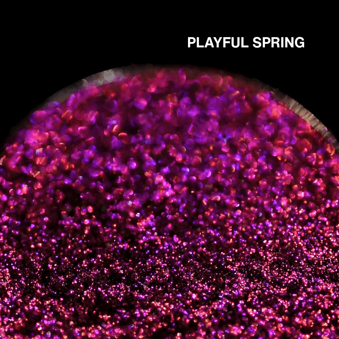 Macro of Playful Spring pressed pan, magenta pink multichrome with violet flash, shade name in white type top right.