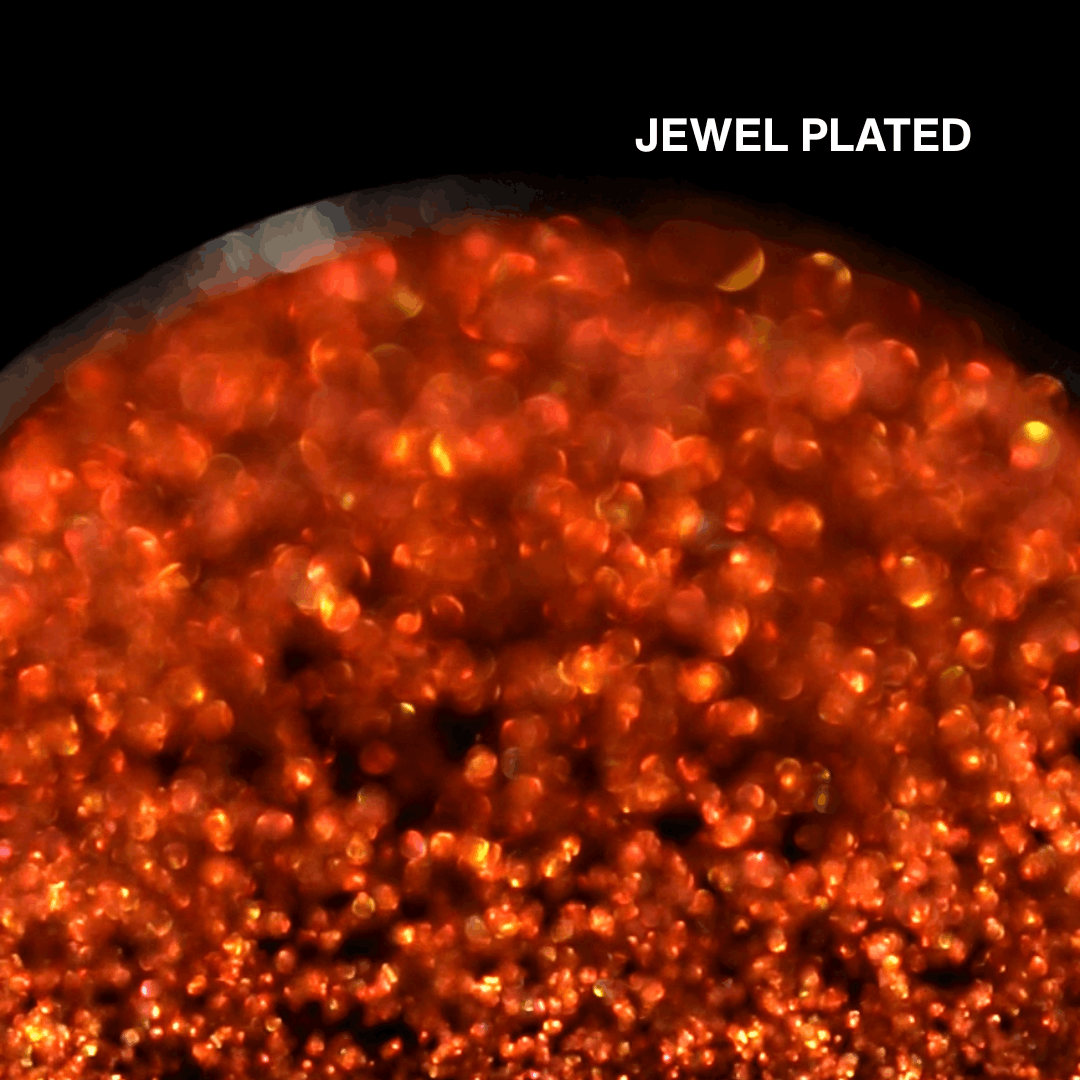 Macro of Jewel Plated pressed pan, fiery orange red multichrome with gold flash, shade name in white type top right.