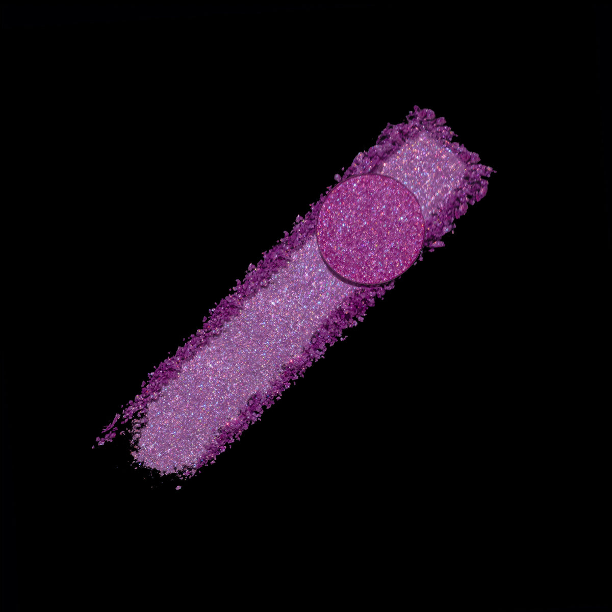 Highlighter pan resting on a smear of the crushed pink-violet powder, on black.