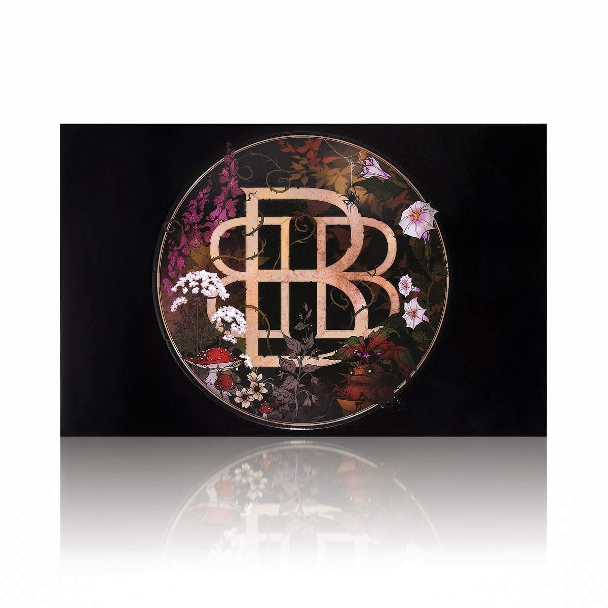 The Garden of Singles lid: a gold Bellabeautebar monogram ringed with wildflowers, mushrooms and leaves, on white