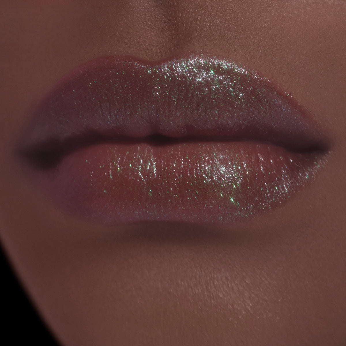 Sheer layer on deeper-skin lips, brown with a green sheen.