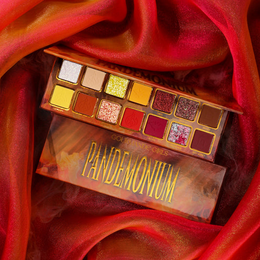Gourmande Girls Pandemonium eyeshadow palette open on red silk, 14 shades in two rows of gold-framed pans, from pale sparkles to yellows, rusts, reds and plum