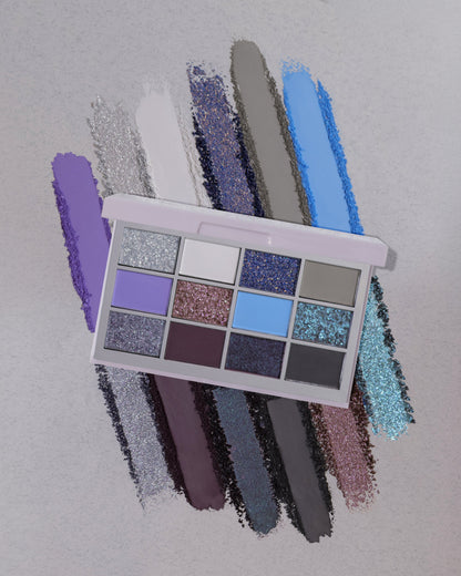 Into the Mist palette laid over smudged swatches of each shade on a pale grey textured background