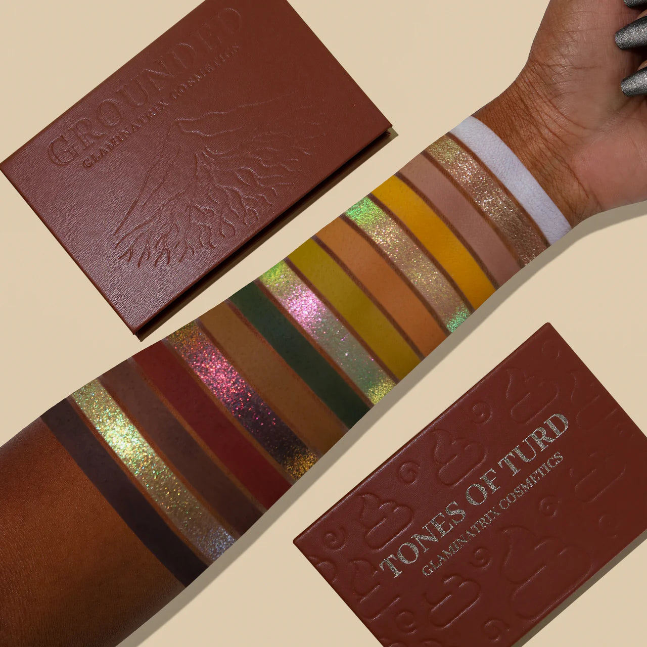 Full shade range swatched on a deep skin tone beside the closed Tones of Turd and Grounded palettes, multichromes shifting green to pink with warm mattes