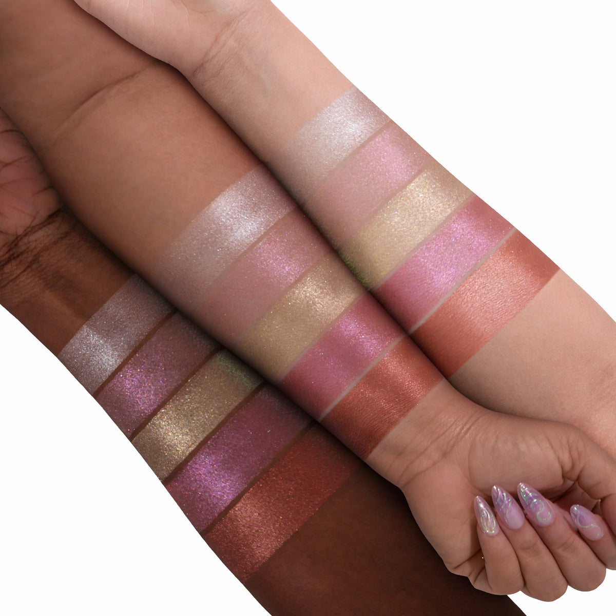 Arm swatches of all five Evocative glazed highlighter shades on two skin tones, from icy champagne and pink through gold and mauve to bronze