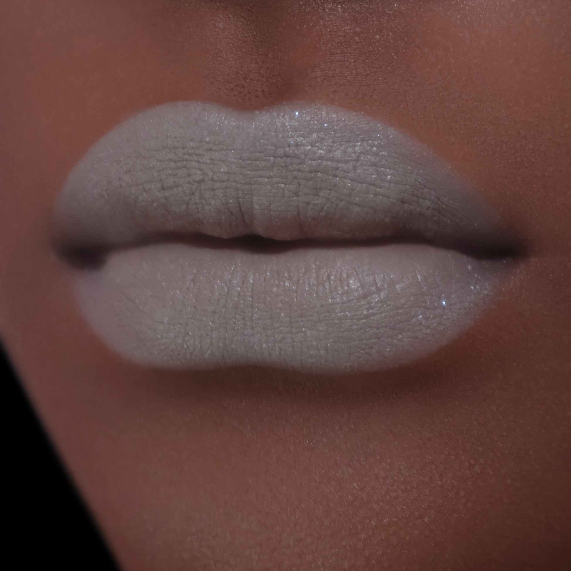 BellaBeauteBar Velvet Veil lip mud in Undivided worn on lips - muted grey green matte finish on deeper skin tone