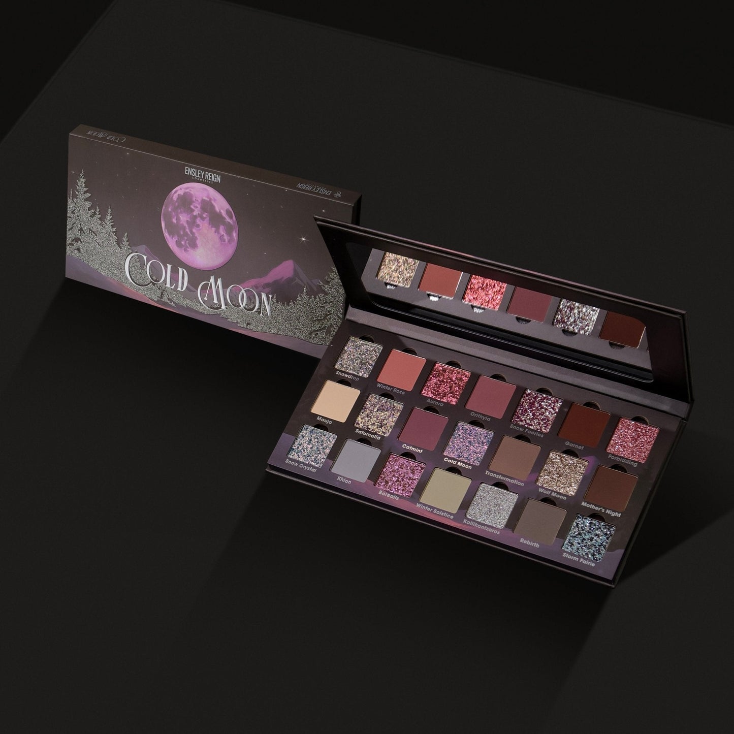 Cold Moon palette angled open next to its closed box on dark background, showing the full 21-shade layout across three rows