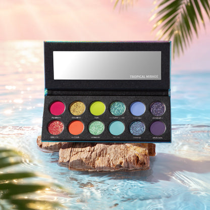 Kryptein Tropical Mirage palette open on driftwood in shallow water, all 12 pans visible with shade names engraved beneath each