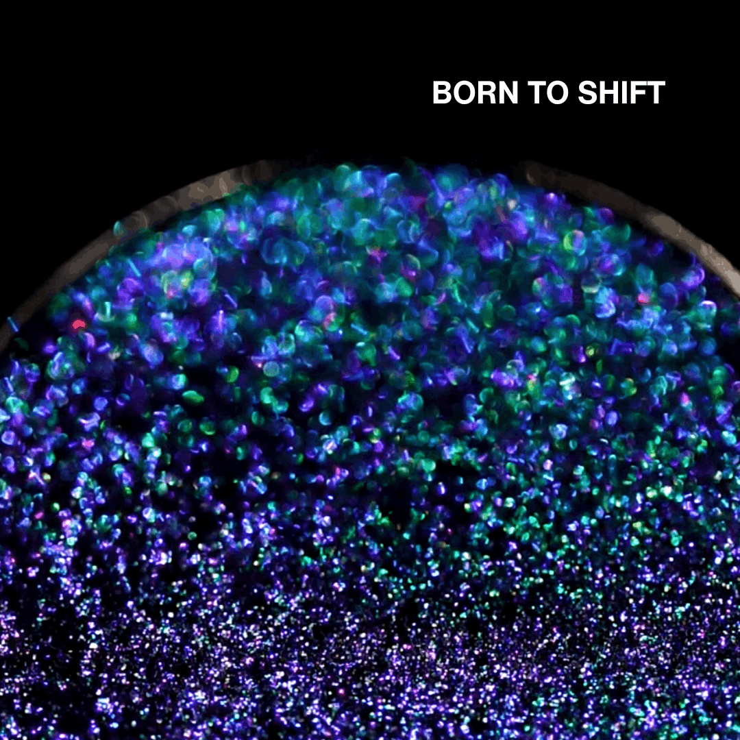 Macro of Born to Shift pressed pan, blue to green to purple multichrome shifting powder, shade name in white type top right.