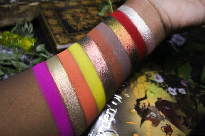 Swatches of ten shades on deep skin, with the palette cover in frame.