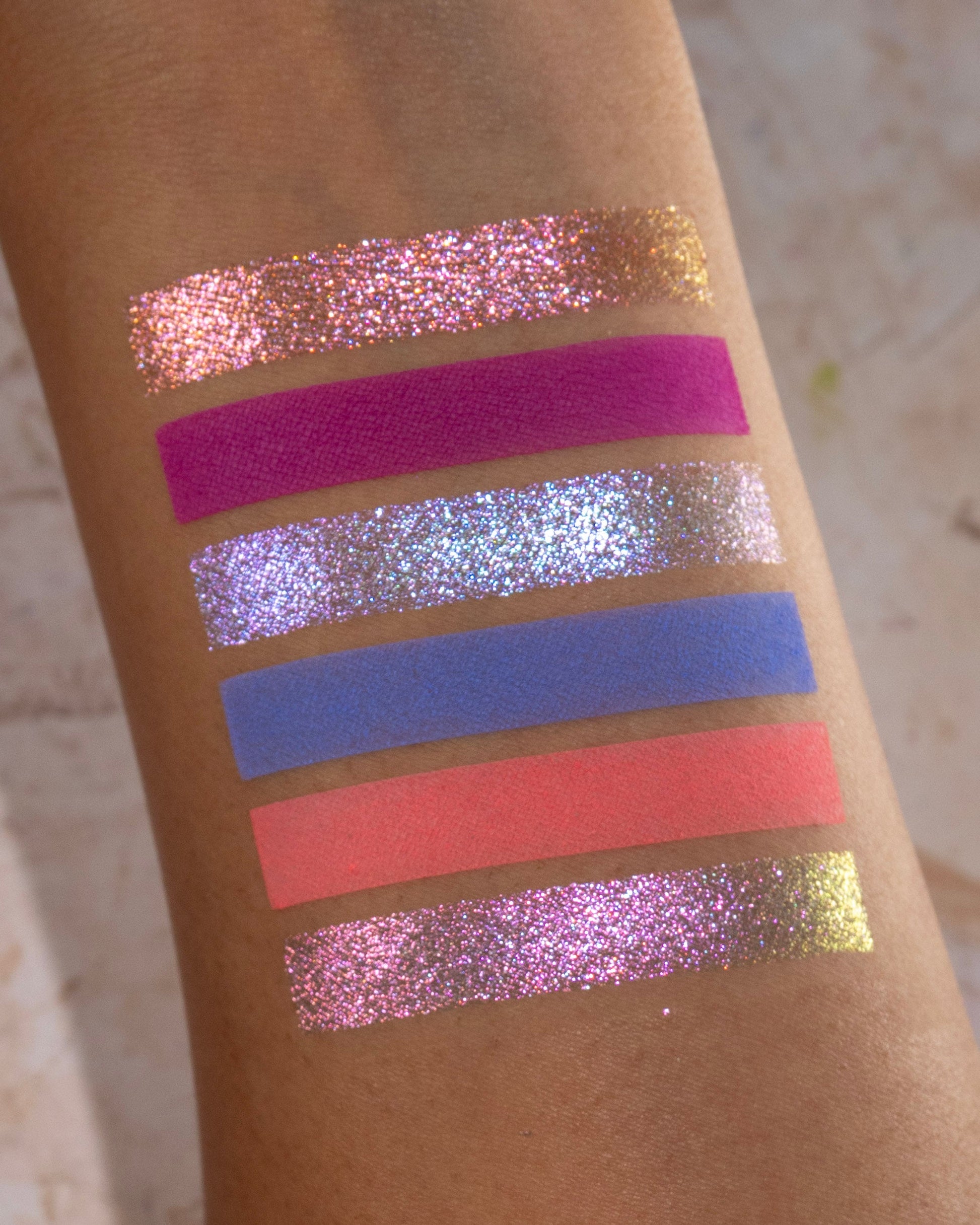 On Cloud 9 shades swatched, magenta, lilac, periwinkle, and coral on skin