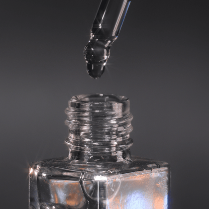 Glass dropper lowering a clear drop into the open neck of the Mixing Medium bottle on a grey background.