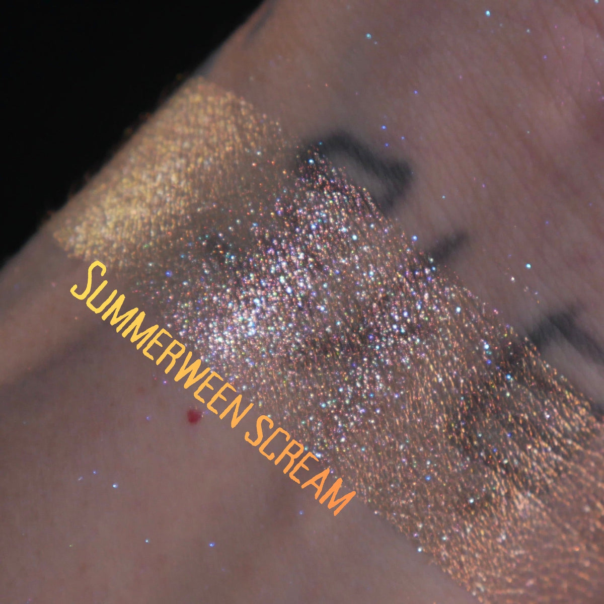 Summerween Scream swatched on light skin against black, gold running into warm copper sparkle.