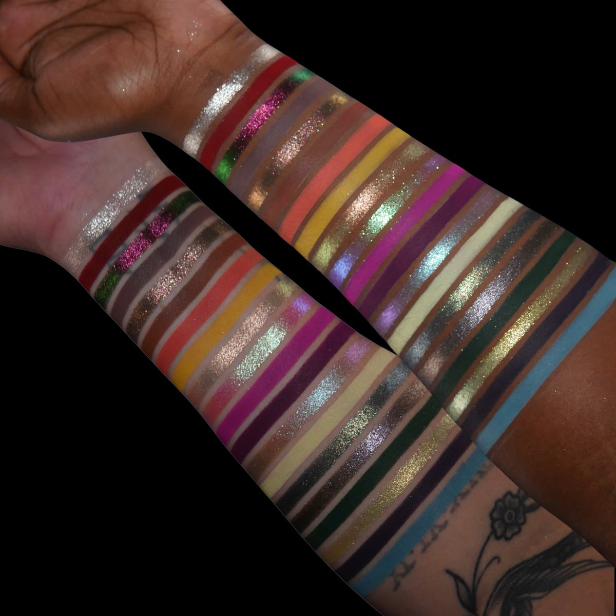 Swatches of every shade on two arms, light and deep skin, against a black background.