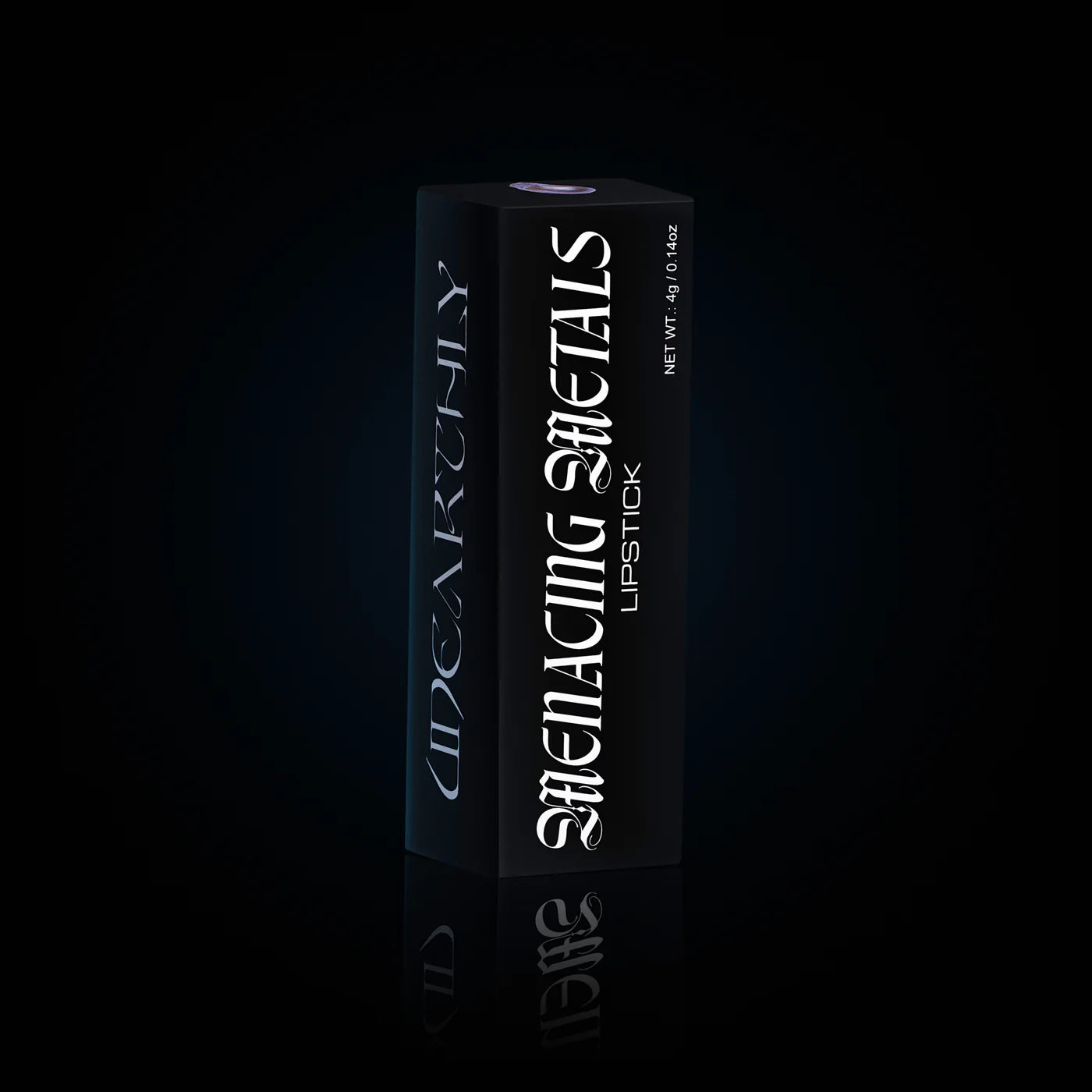 Menacing Metals lipstick carton standing on a black reflective surface, tall matte black box with the shade window on top