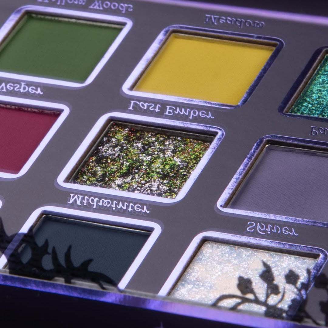 Black Spring palette close-up showing Hollow Woods green matte, Meadow yellow matte, and Last Ember red and gold multichrome sparkle pans