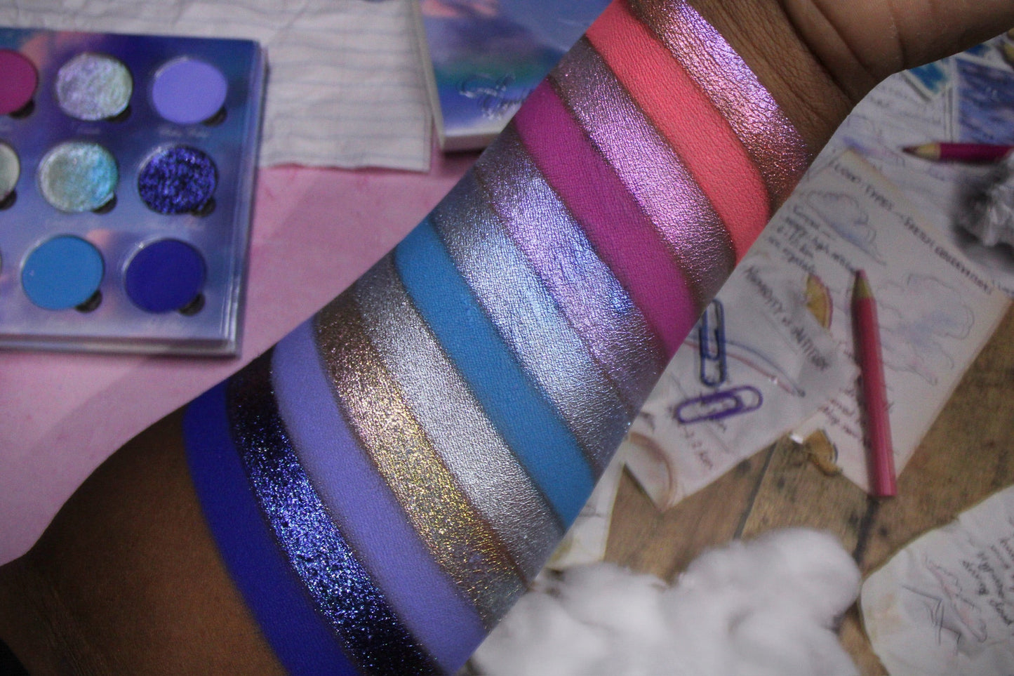 On Cloud 9 palette open at an angle beside arm swatches on a desk