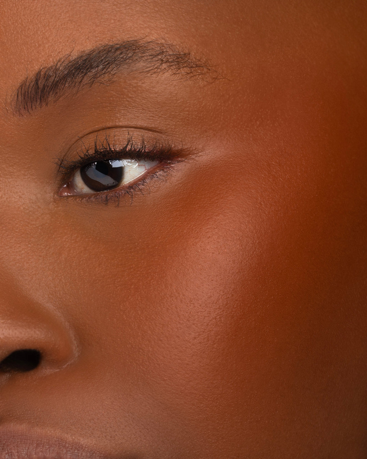 October on the cheek as a warm rust flush, deep skin tone