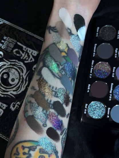 BellaBeauteBar Yin & Yang x Freya86_ff palette swatched on a tattooed arm — holographic glitters, duochromes, and deep mattes alongside the open palette