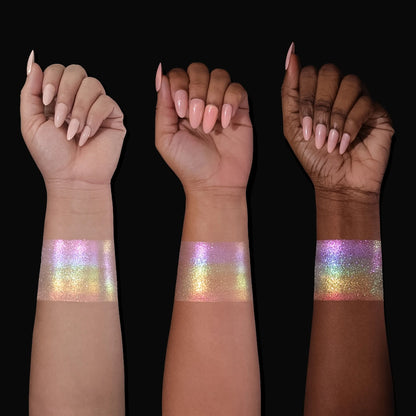Arch of Color highlighter swatched on light, medium, and deep skin tones, showing an iridescent pink, lilac, gold, and green rainbow shift