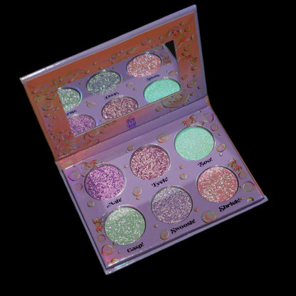The palette open on a black background, the six labelled pans reflected in the mirrored lid.