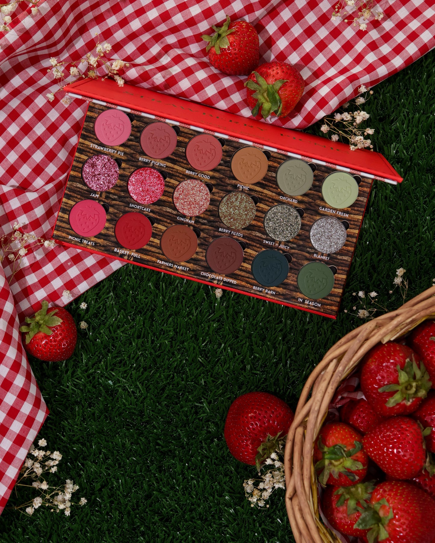 Strawberry Picnic palette open on red gingham and grass with fresh strawberries and a basket