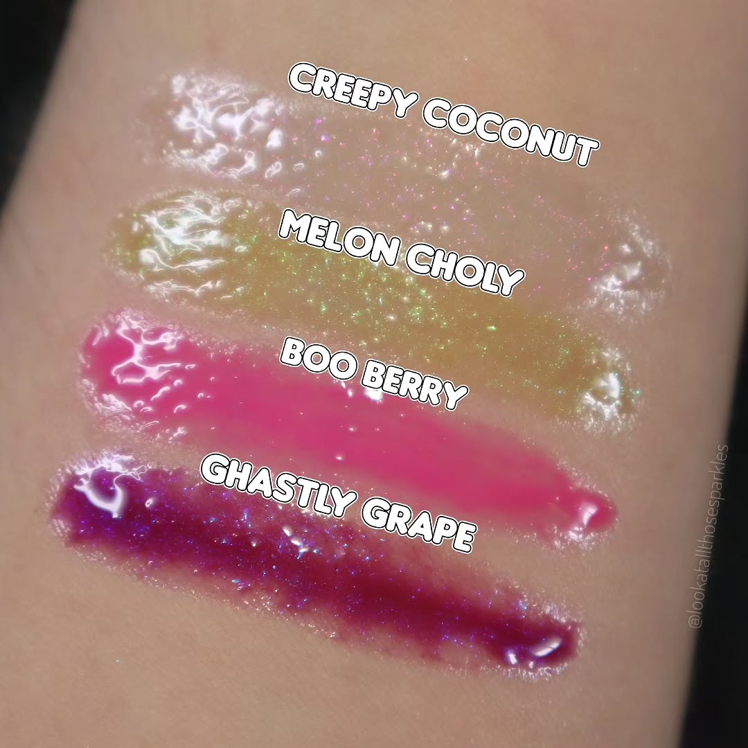 Thick arm swatches of the four glosses labelled Creepy Coconut, Melon Choly, Boo Berry and Ghastly Grape