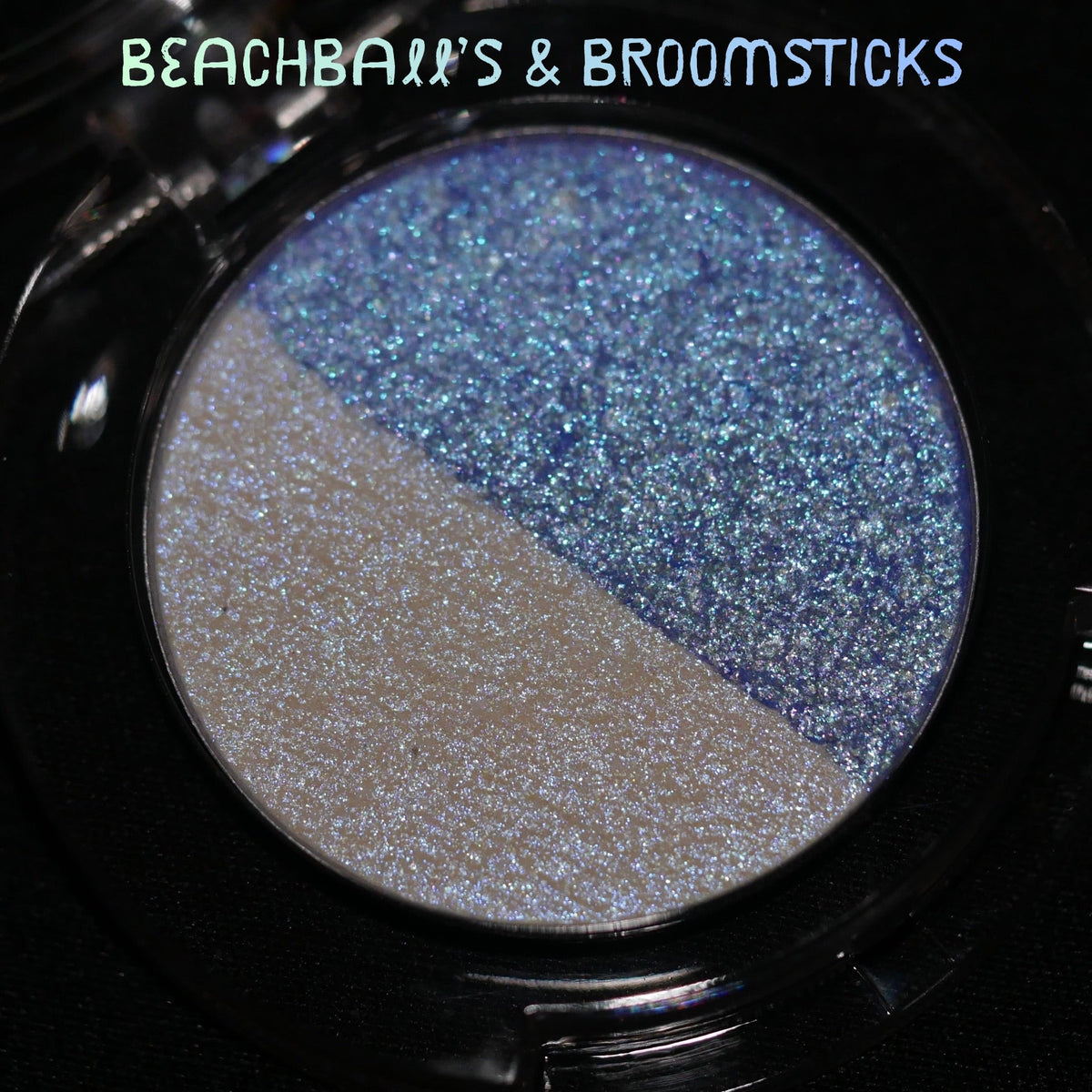 The Beachballs and Broomsticks pan in a black compact, split between cream and a blue sparkle half.