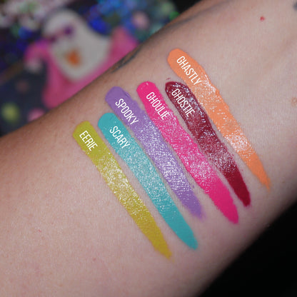 Six labelled diagonal arm swatches on light skin, Eerie, Scary, Spooky, Ghoulie, Ghostie and Ghastly, with a ghost print behind.