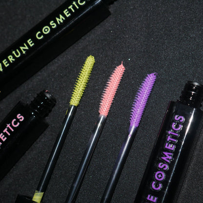 Three loaded wands laid between two tubes on black fabric, chartreuse, coral and orchid.